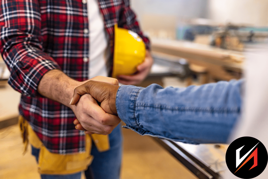 Construction workers shaking hands in workshop