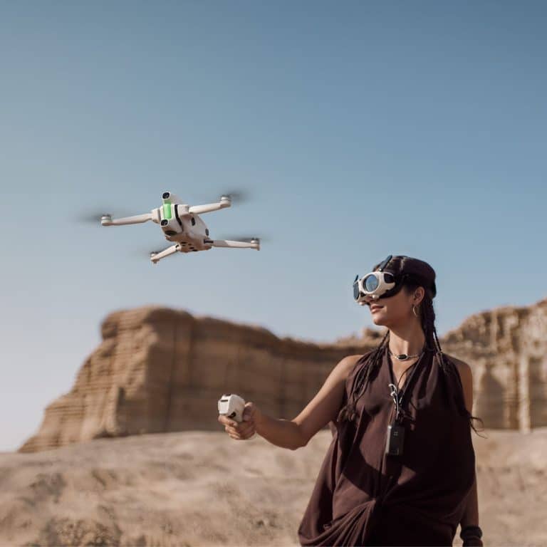 Person flying drone with goggles in desert