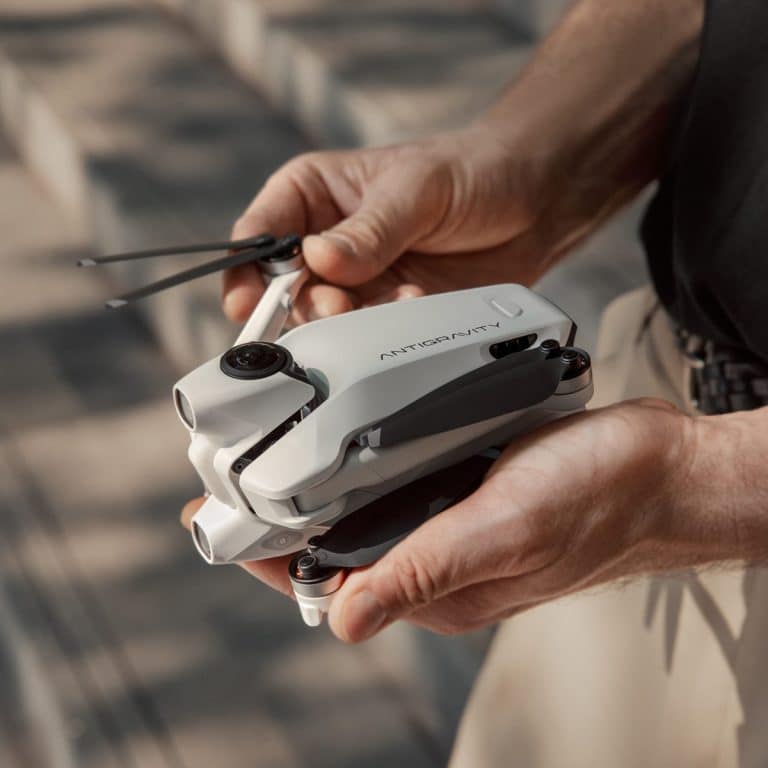 Person holding compact folding drone outdoors