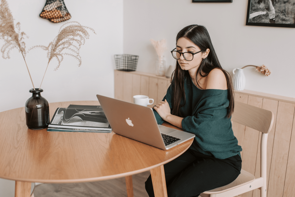 Woman working on laptop at wooden table