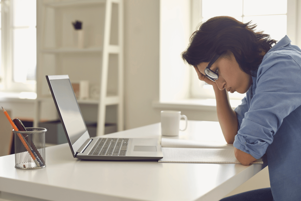 Stressed person working at laptop desk