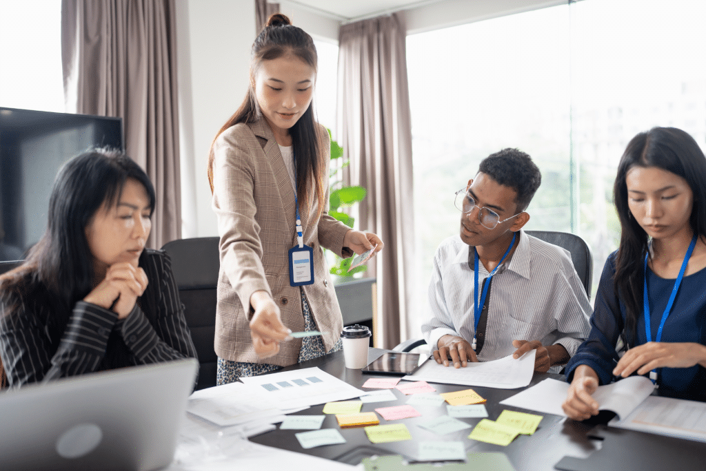 Team meeting with woman presenting ideas at office table